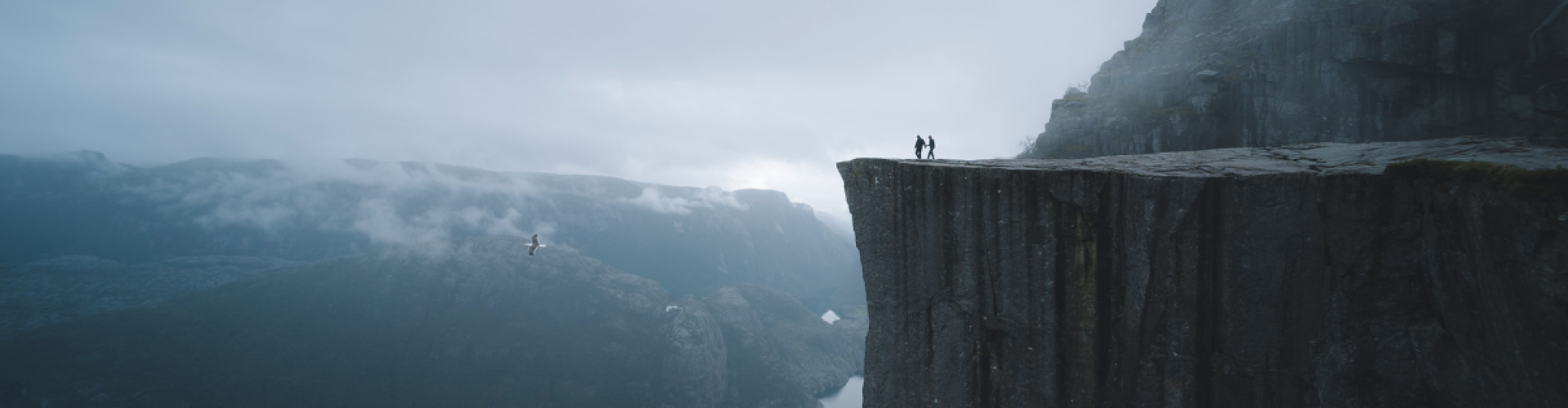 Two people standing at the edge of a cliff, symbolizing strategic foresight and risk management